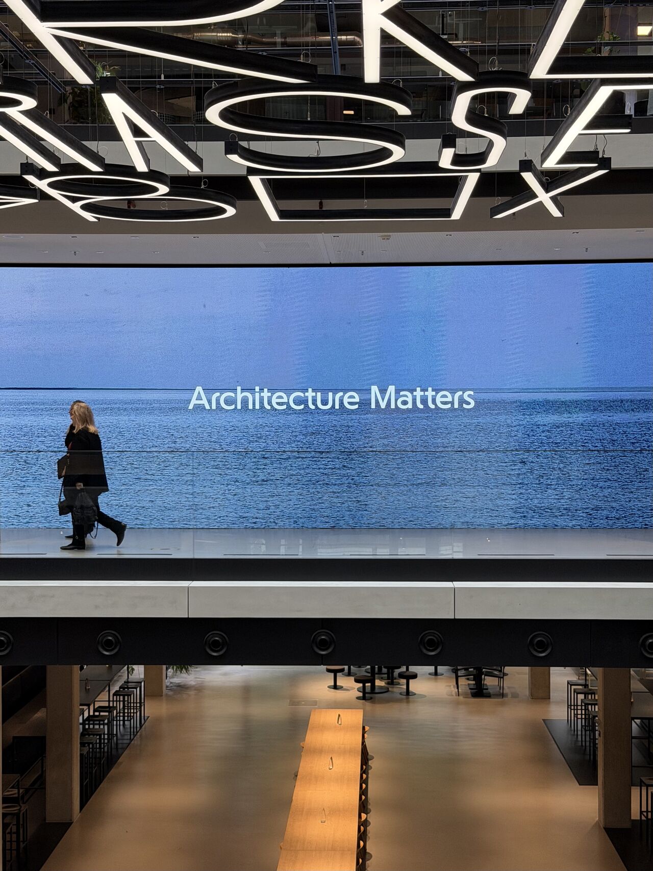 Person geht an einer großen Leinwand mit dem Schriftzug „Architecture Matters