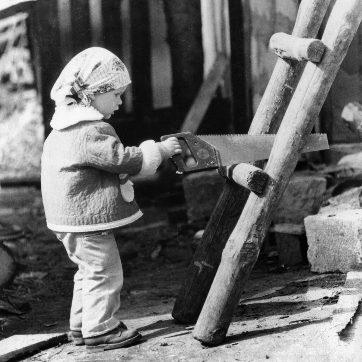 Anna Galinovskaya als Kind, etwa 1991, mit einer Säge am Holzgerüst